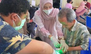 Kepala UPT Zona 1 Disdukcapil Lutia Nazla,SIP saat Layani Lansia. Foto : Noto